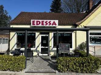 Edessa Schnellrestaurant Gelb verputztes Schnellrestaurant mit rotem Schriftzug Edessa und kleiner Terrasse mit Sitzplätzen.