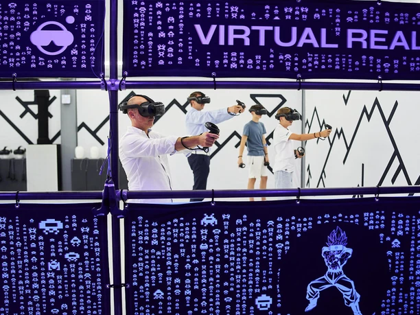 7th Space Köln Menschen mit VR-Brillen tauchen in eine virtuelle Realität in einem futuristischen Raum ein.