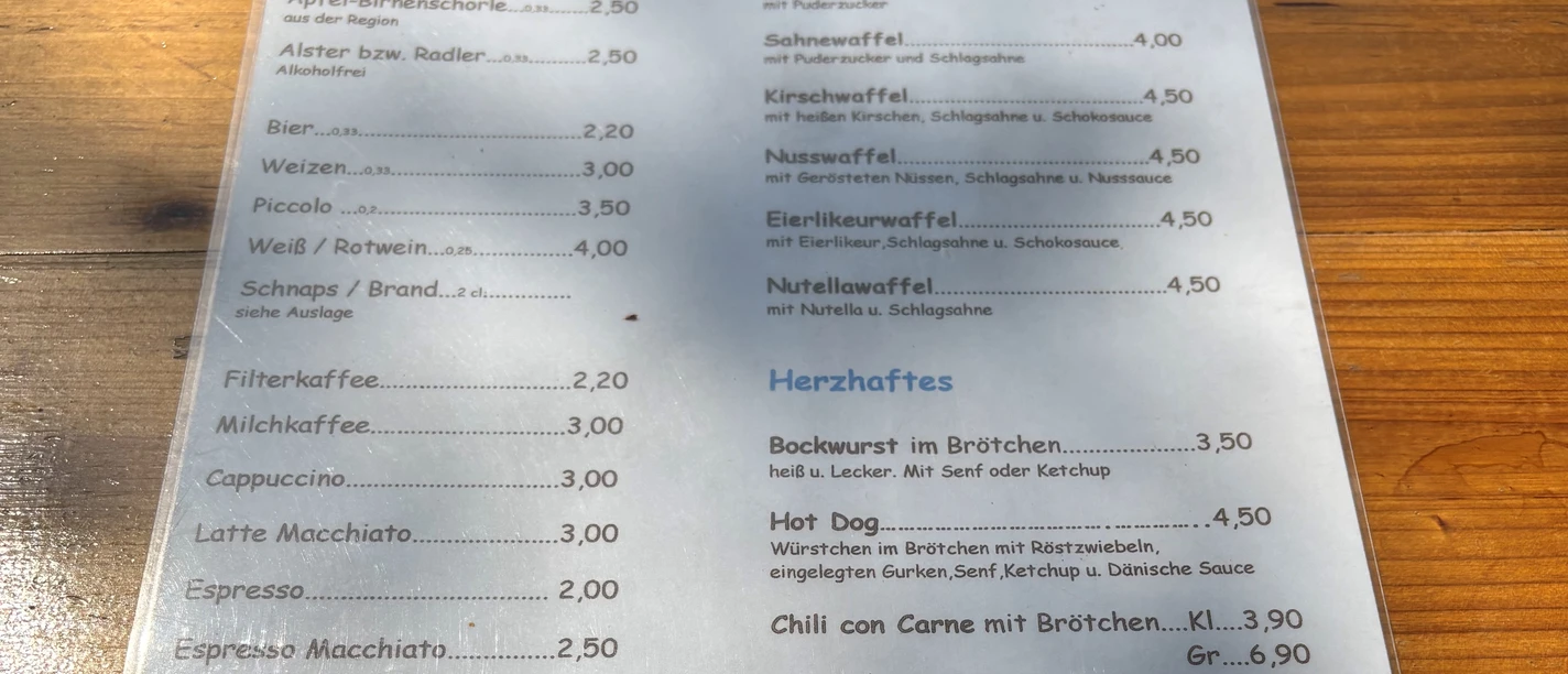 Wandelbar Karte Speisekarte im Freien mit Getränken, Waffeln und herzhaften Snacks wie Brötchen und Chili.