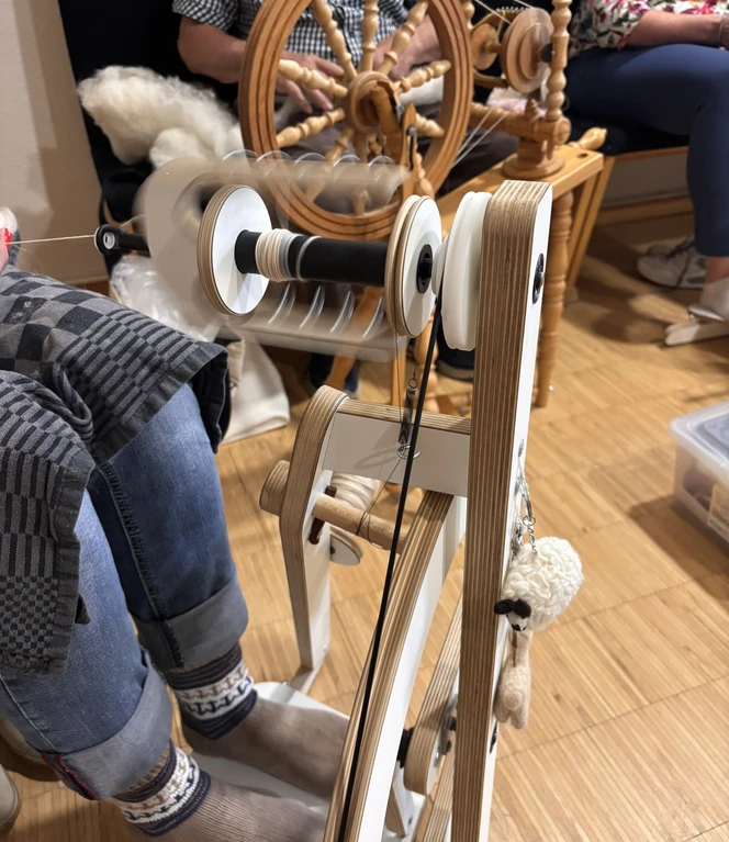 Gleichmäßig bewegt sich das Spinnrad während der Unterhaltungen