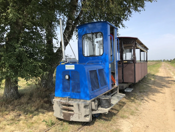 Moorbahn Uchte Eine historische Moorbahn in blau auf schmaler Schiene vor einem Baum und einem weiten, klaren Himmel.A historic moorland railroad in blue on a narrow track in front of a tree and a wide, clear sky.En historisk hedejernbane i blåt på et smalt spor foran et træ og en bred, klar himmel.Een historische veenbaan in blauw op een smal spoor voor een boom en een heldere lucht.