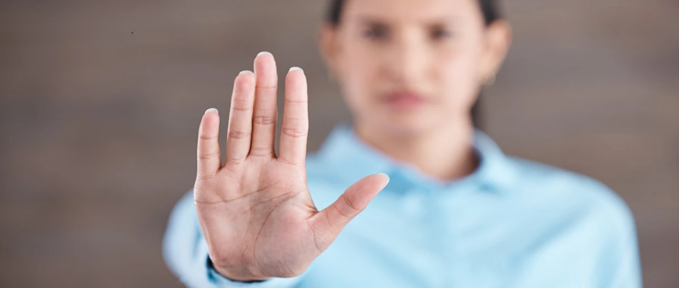 Stop, hand sign and woman with no gesture for sexual harassment and violence in workplace. Business professional, palm and female employee at company with stopping emoji for gender rights at job