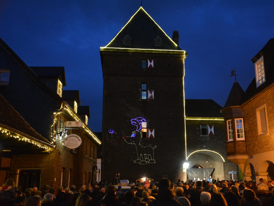 Turmblasen am Schelmentur Eine große Menschenmenge versammelt sich vor einem beleuchteten Turm zum traditionellen Turmblasen.