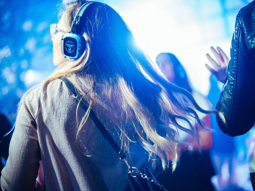 Altstadt, Silent Party Menschen tanzen bei einer Silent Party mit Kopfhörern auf, im verschwommenen blauen Hintergrund.