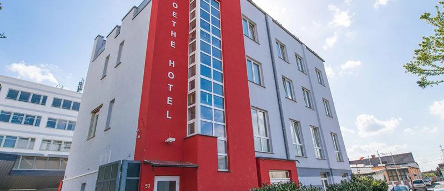 Goethe Hotel A red and gray hotel building "Goethe Hotel" with blue windows.