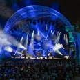 Kings of Floyd - „Dark Side“-Tour 2026 Open-Air-Konzert bei Nacht mit blauer Bühnenbeleuchtung und einem großen, gefüllten Zuschauerbereich.