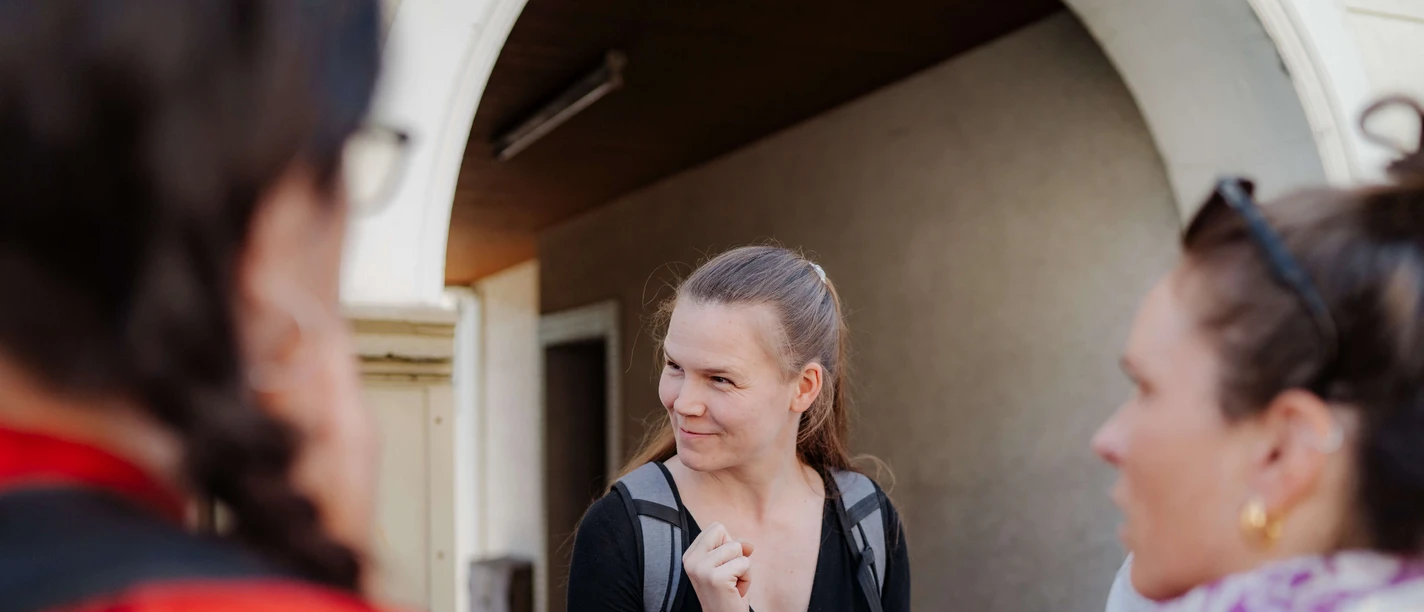 Rätseltour Heiligenhaus Junge Erwachsene stehen im Gespräch mit Smartphones in der Hand, vor einem Torbogen in Heiligenhaus.