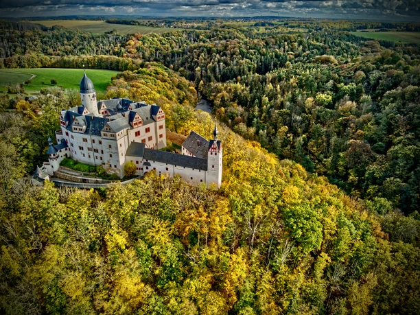 Lunzenau_Schloss Rochsburg_(c)Instagram _lng_photography__CC BY-SA (1).JPEG Das Foto zeigt einen Luftaufnahme von Schloss Rochsburg. Das Schloss ist umgeben von einem golden schimmernden Herbtwald.