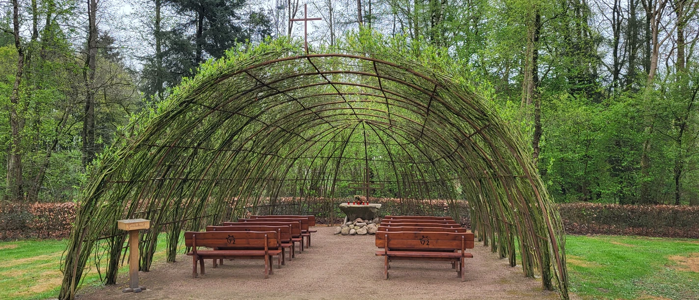 Weidenkirche Bruneforth, Stavern ©Naturpark Hümmling.jpg Offene Weidenkirche mit gewölbtem Flechtwerkdach, Holzbänken und Altar inmitten grüner Natur