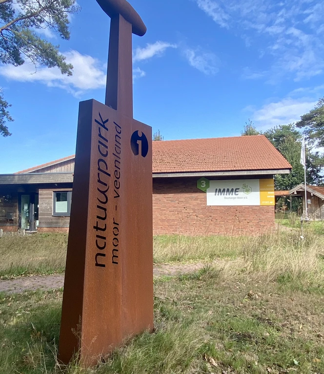 Deutsch-Niederländisches Bienenzentrum in Haren (Ems) - Oplegger ©Naturpark Moor-Veenland Rostfarbene Infostele vor dem Gebäude des Deutsch-Niederländischen Bienenzentrums im Naturpark.