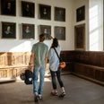 Der Friedenssaal im Osnabrücker Rathaus Zwei Besucher betrachten Gemälde in einem historischen Raum mit Holztäfelung und großen Fenstern.Two visitors look at paintings in a historic room with wood paneling and large windows.To besøgende kigger på malerier i et historisk rum med træpaneler og store vinduer.Twee bezoekers bekijken schilderijen in een historische kamer met houten lambrisering en grote ramen.
