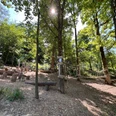 Niedrigseilgarten in Heiligenhaus Niedrigseilgarten in Heiligenhaus mit hölzernen Kletterelementen, umgeben von Bäumen und Sonnenlicht.