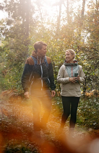 Wandern im Osnabrücker Land Zwei Personen wandern im sonnendurchfluteten Wald bei herbstlicher Stimmung.