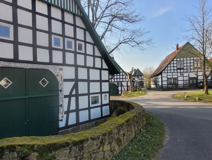 Ein klassisches Fachwerkensemble mit schwarzweißen Fassaden säumt eine ruhige Dorfstraße.
