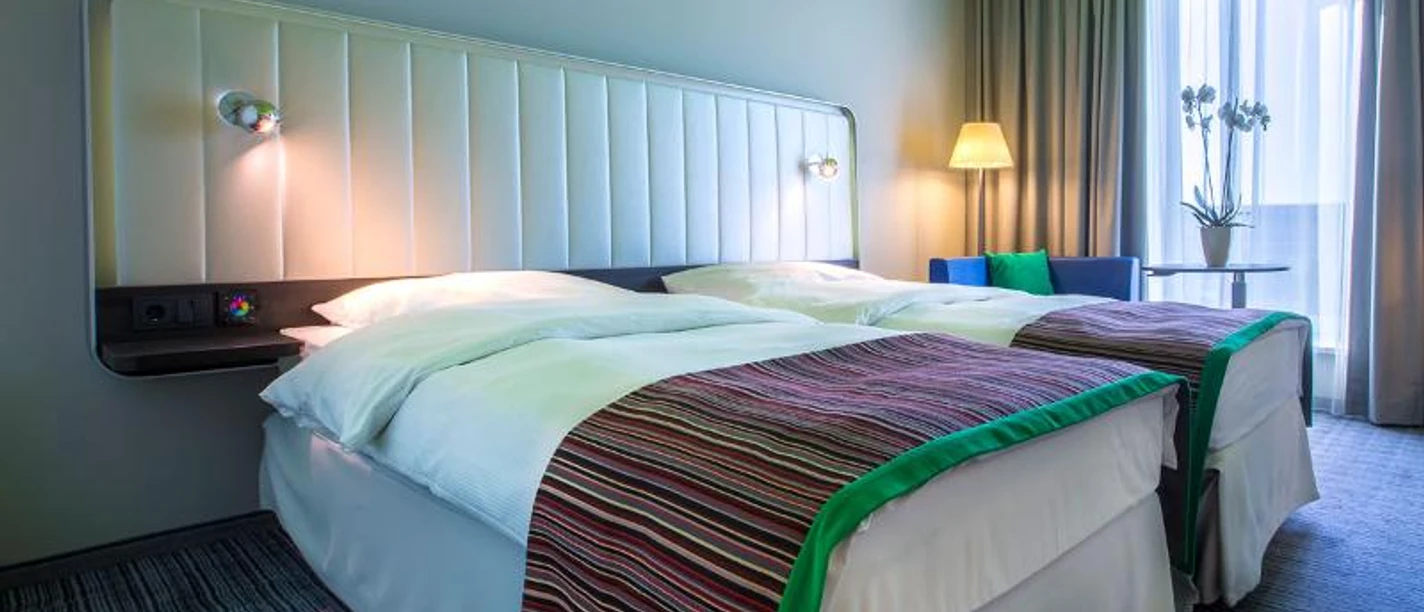 Park Inn by Radisson Frankfurt Airport Ein buntes Hotelzimmer im Park Inn by Radisson Frankfurt Airport mit zwei Betten.