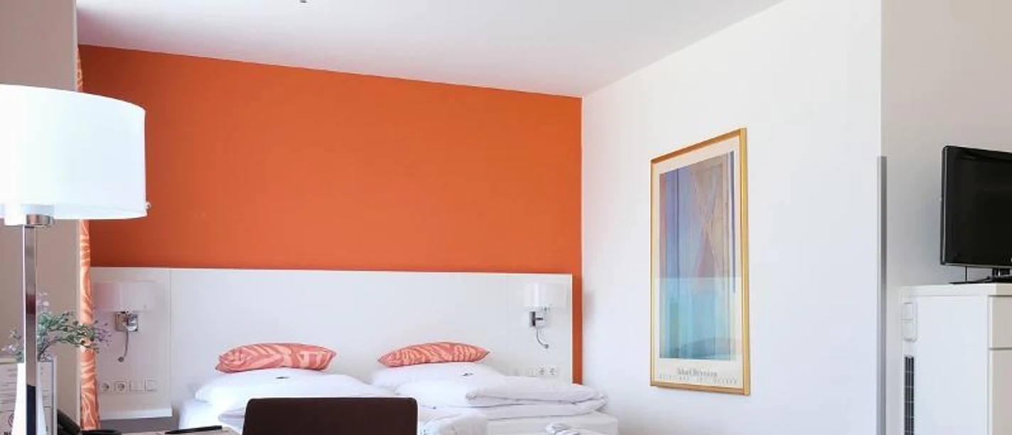 relexa Hotel FrankfurtMain Ein modernes Hotelzimmer im relexa Hotel FrankfurtMain mit oranger Akzentwand.