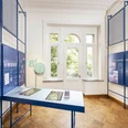 MuseumsquartierVilla2024_030.jpg Ein heller Museumsraum mit blauen Infotafeln, einem großen Fenster und einer interaktiven Station.