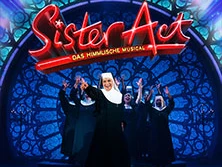 Sister Act Musical: Ordensschwestern tanzen in mitreißender Inszenierung vor farbenfrohem Bühnenhintergrund.