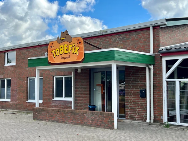 Tobefix Tobefix Ranzgolf befindet sich in einem Backsteingebäude mit grünem Vordach und einladendem Eingang.