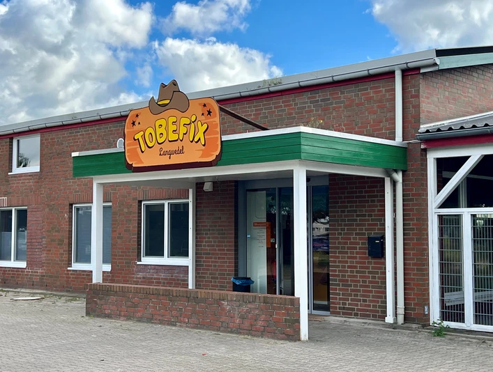 Tobefix Tobefix Ranzgolf befindet sich in einem Backsteingebäude mit grünem Vordach und einladendem Eingang.