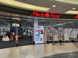 Eingang des MediaMarkt-Elektronikfachmarktes im Einkaufszentrum mit roten Firmenschriftzug.