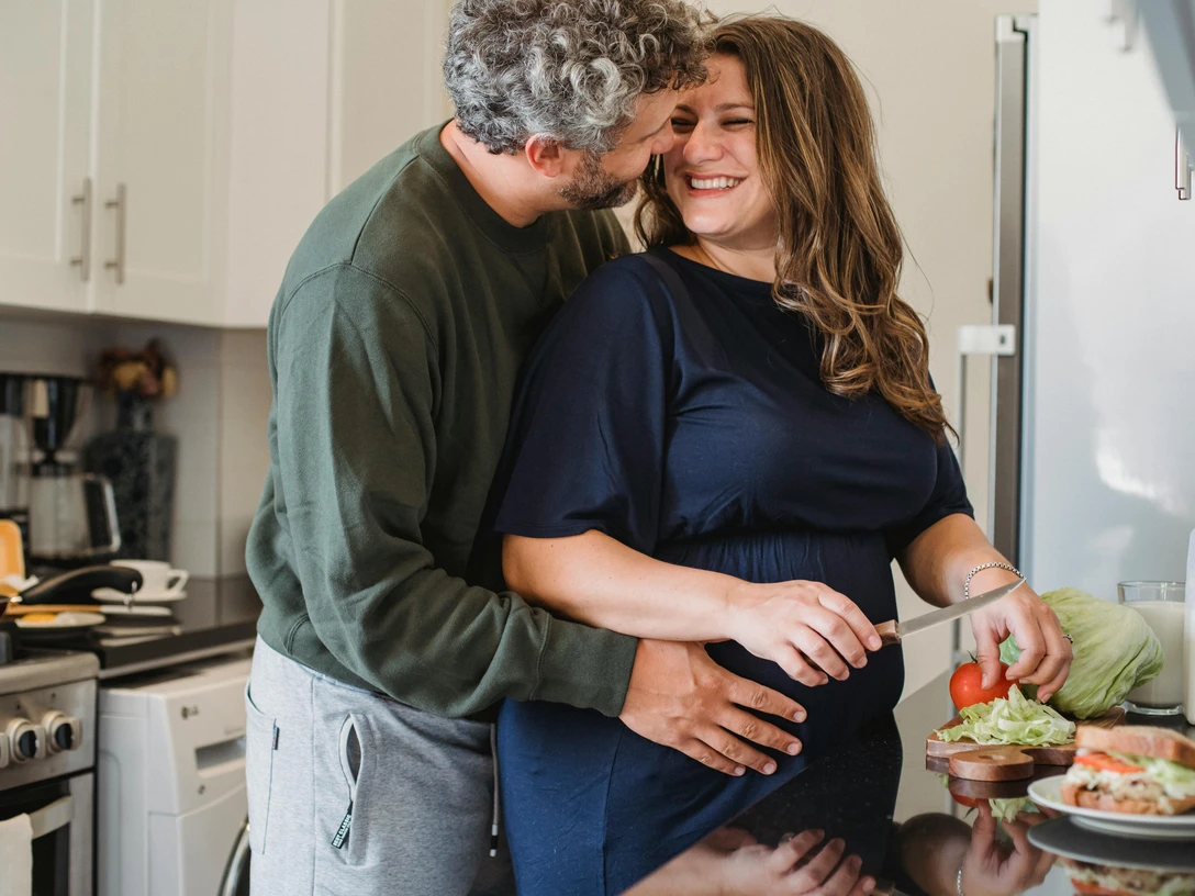 pexels-amina-filkins-5427922.jpg Ein fröhliches Paar kocht gemeinsam in einer modernen Küche; sie schneiden frisches Gemüse.