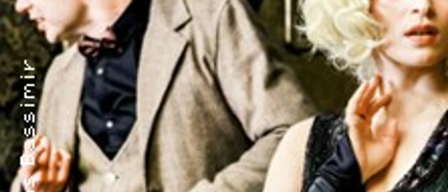 Zwei Personen in Retro-Kleidung stehend, in einem dramatischen Theatermoment vertieft.