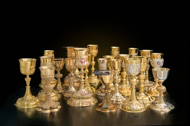 Dommuseum - Licht und Farbe Goldene und silberne Kelche auf dunklem Hintergrund
