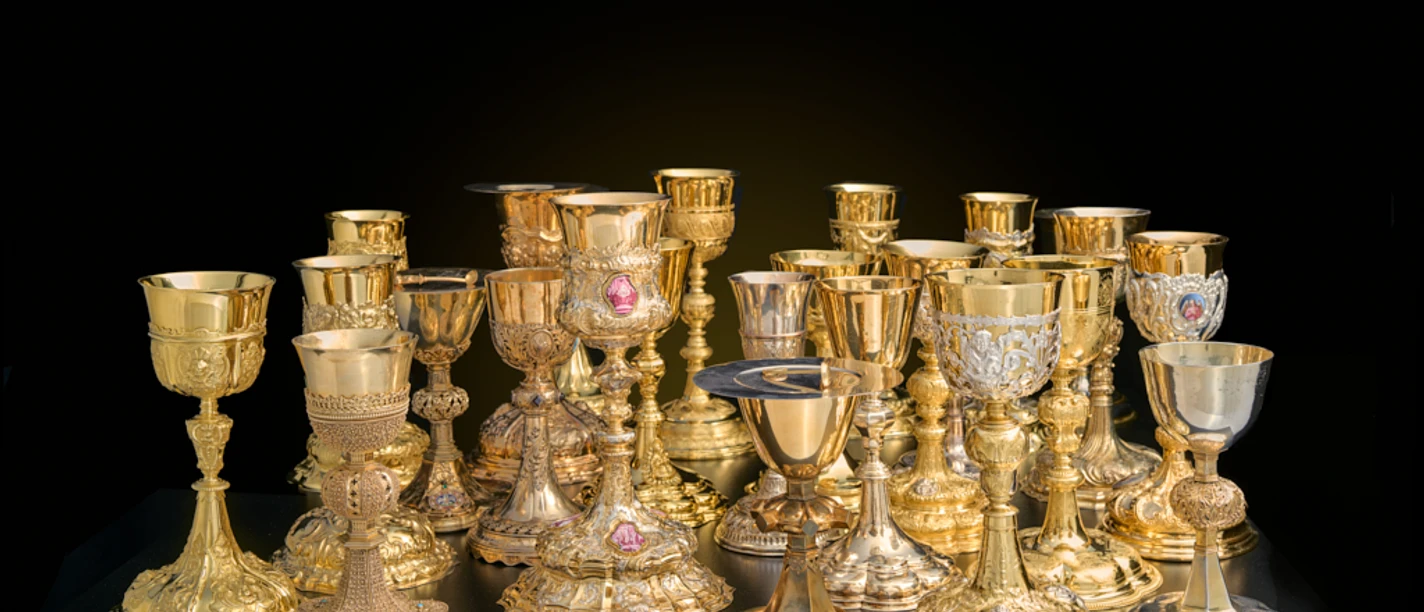 Dommuseum - Licht und Farbe Goldene und silberne Kelche auf dunklem Hintergrund
