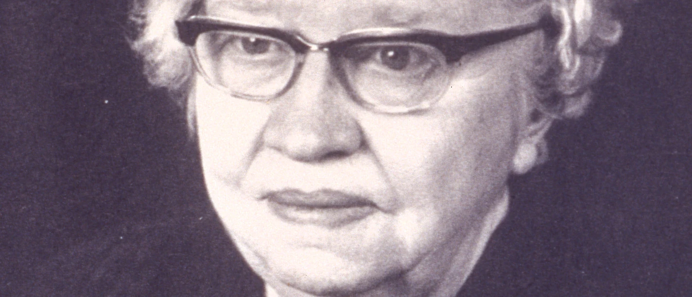 Portrait Maria-Mönch Tegeder ©Kreisarchiv Emsland (N 6 Nr. 5083).jpg Porträt einer älteren Frau mit Brille, kurzem hellem Haar und Perlenkette vor dunklem Hintergrund