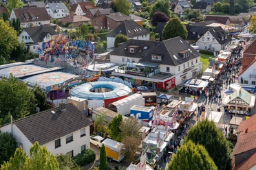Gesmolder Kirmes von oben.jpg Luchtfoto van een drukke kermis met kleurrijke attracties en bezoekers.