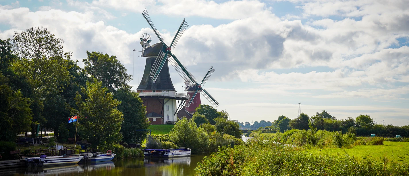 Greetsieler Zwillingsmühlen und Bootsanleger Zu sehen sind die beiden Zwillingsmühlen Greetsiel und im Vordergrund ein paar Boote vom Bootsanleger.