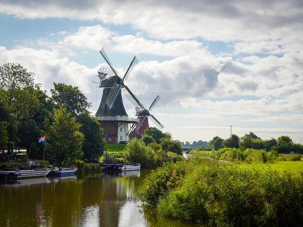 Greetsieler Zwillingsmühlen und Bootsanleger Zu sehen sind die beiden Zwillingsmühlen Greetsiel und im Vordergrund ein paar Boote vom Bootsanleger.