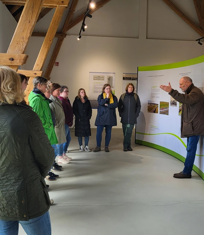 Lehrerfortbildung am Theikenmeer_Naturpark Schule Bernhardschule ©Naturpark Hümmling Gruppe von Lehrkräften hört in einer Ausstellungshalle einem Vortragenden zu, Thema Natur und Umwelt.