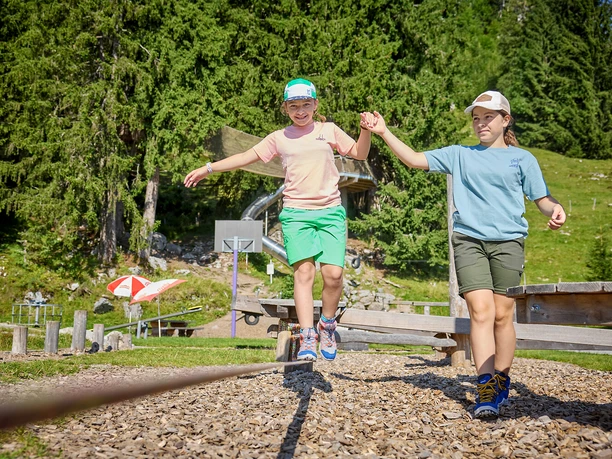 Zwei Mädchen auf dem Balancierpfad auf dem Spielplatz Stockhütte.