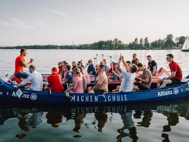 SPORT SPEAKER Kanu Team Event Seeminar 00 (c) Martin Schneegang ganscool.media.jpg Mehrere gefüllte Kanus auf dem Wasser beim Sport Speaker Team Event