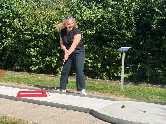 Besucherin spielt Minigolf