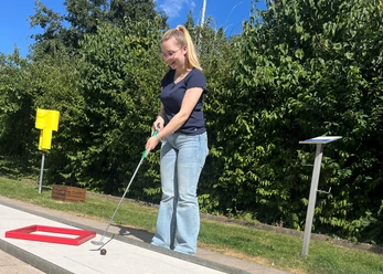 Besucherin spielt Minigolf