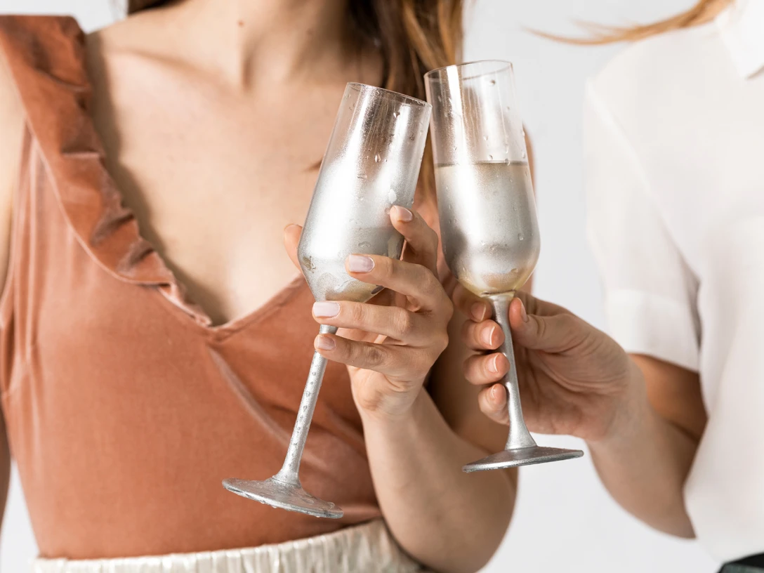 Frauenflohmarkt.png Zwei Frauen mit je einem Glas Sekt in der Hand stoßen an
