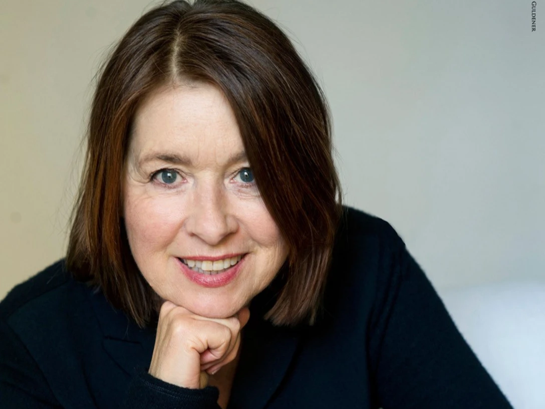 260412-Franziska-Walser- Foto Janine Guldener.jpg Porträtfoto von Franziska Walser lächelnd, mit schulterlangem Haar, vor hellem Hintergrund.