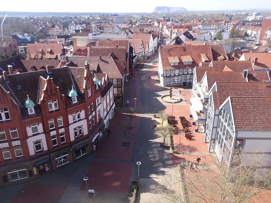 Blick vom Stadtkirchturm Richtung Lange Str. - R. Kranz.jpg Luftaufnahme einer historischen Stadt mit roten Ziegeldächern, einer Fußgängerzone und Fachwerkhäusern.