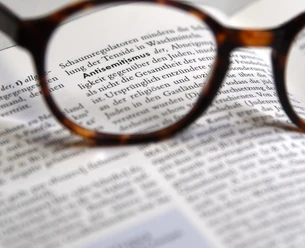 Verschriftlichte_Definition__Antisemitismus_.JPG Brille fokussiert den Lexikonbegriff Antisemitismus auf einer aufgeschlagenen Seite.