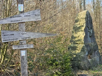 Bad-Driburg-Langeland_Bodostein-1.jpg Wegweiser aus Holz zeige die Richtungen zu Bad Driburgs Ortschaften, daneben steht der Bodostein