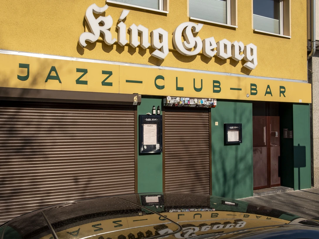 King Georg King Georg Jazzclub mit gelber Fassade und geschlossenen Rollläden, Köln bei Tageslicht.King Georg Jazzclub with yellow facade and closed shutters, Cologne by daylight.
