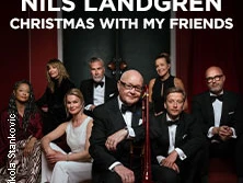 Nils Landgren und sieben elegant gekleidete Personen posieren in Abendgarderobe mit Musikinstrumenten.