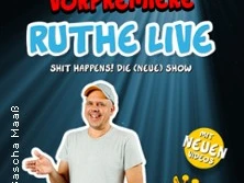 Ralph Ruthe steht in lässiger Pose, mit einem hellen T-Shirt vor dem Tourposter für "Ruthe Live".