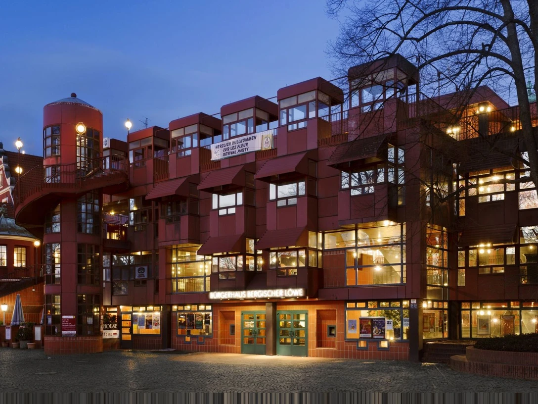 Bergischer Loewe Rotes Kulturzentrum mit auffälliger Architektur bei Abenddämmerung.
