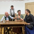 Der-verkaufte-Großvater-Theater-Aibling-1.jpg Vier lachende Schauspieler in Trachten sitzen um einen Tisch und stoßen mit Schnapsgläsern an.