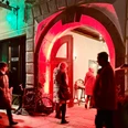 Winterhofnacht Pirna Menschen flanieren durch einen rot erleuchteten Torbogen bei einer Abendveranstaltung im Winter.People stroll through a red-lit archway at an evening event in winter.Lidé procházejí červeně osvětleným obloukem během zimní večerní akce.Ludzie przechadzają się po oświetlonym na czerwono łuku podczas wieczornego wydarzenia w zimie.Mensen wandelen door een roodverlichte boog tijdens een avondevenement in de winter.Le persone passeggiano attraverso un arco illuminato di rosso durante un evento serale in inverno.