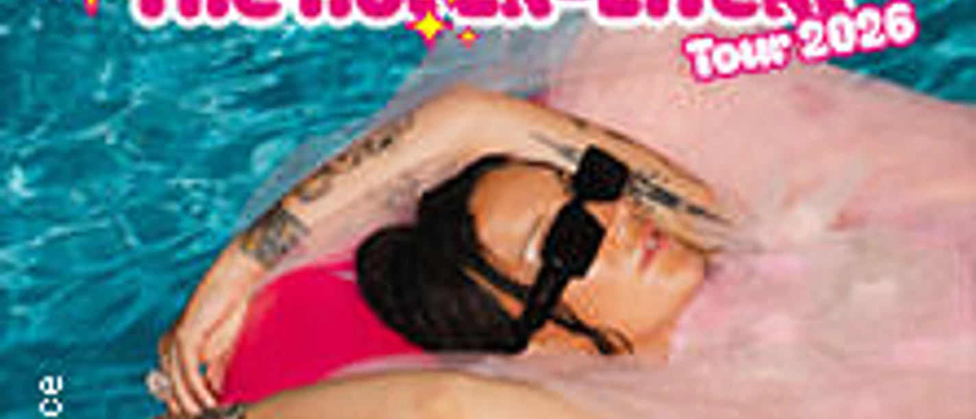 Eine Person entspannt im Wasser auf einem pinken Schwimmring, umgeben von blauen Wellen.
